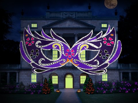 Image: A mask lit up over the facade of the museum